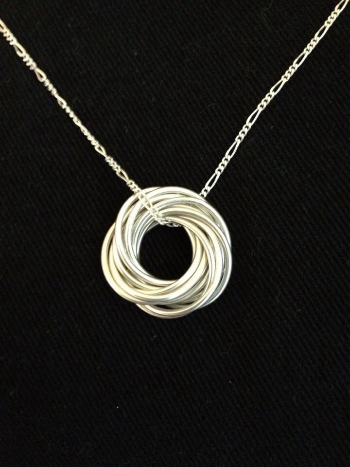Fiddle pendant - 12 interlocking rings on a long figaro chain.  Sterling Silver